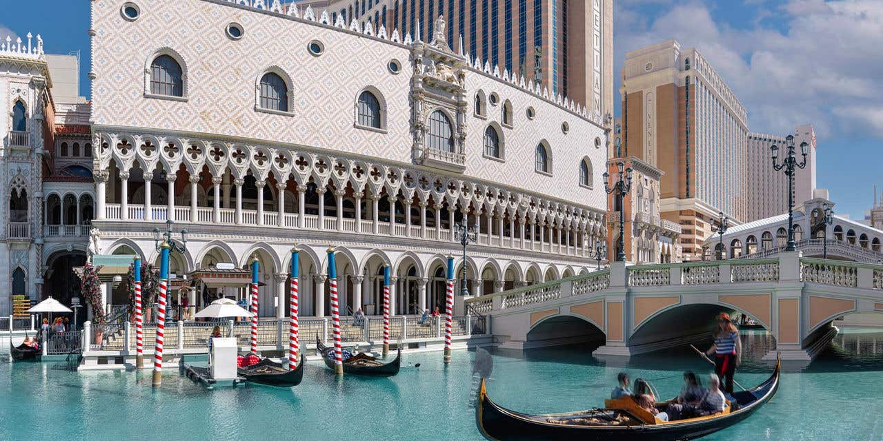 Exterior of The Venetian Resort at daytime, showing a gondola on the grand canal.