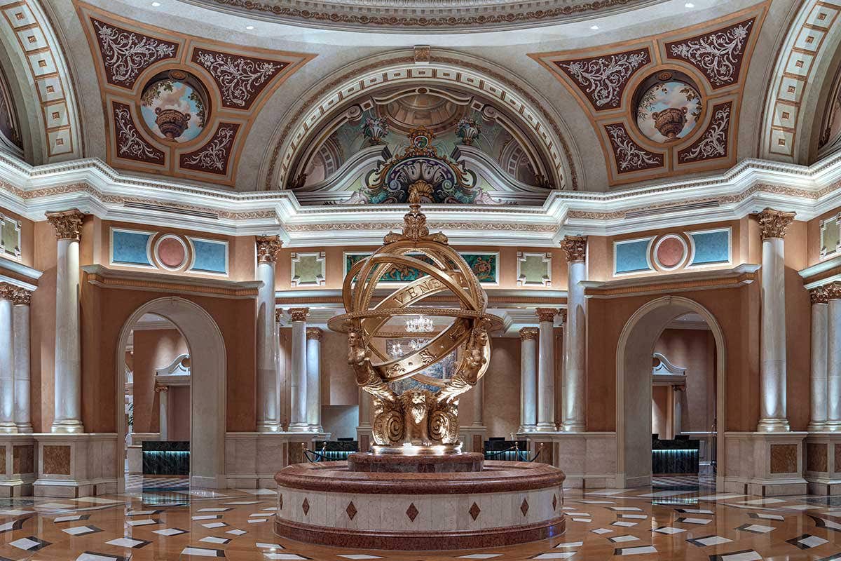 A large armillary sphere statue in the middle of an opulent lobby.