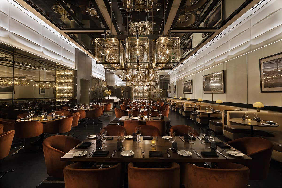 A modern, elegant restaurant with dim lighting, upscale decor, and neatly arranged tables and chairs.