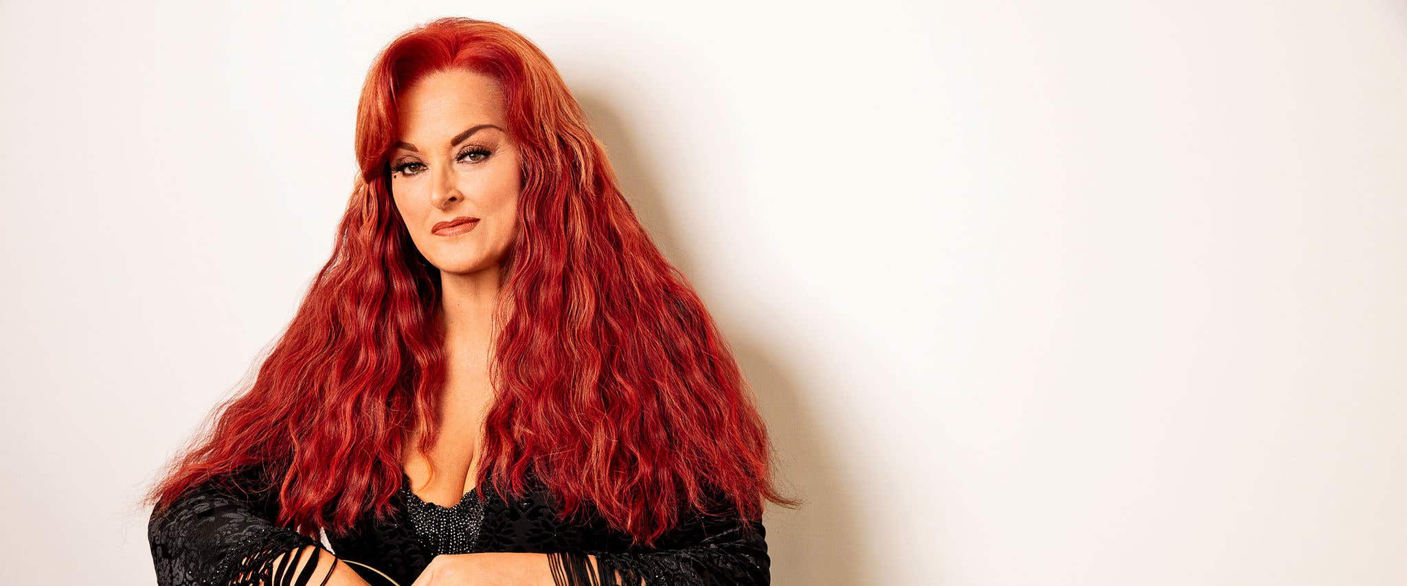 Wynonna Judd wearing black against a white backdrop