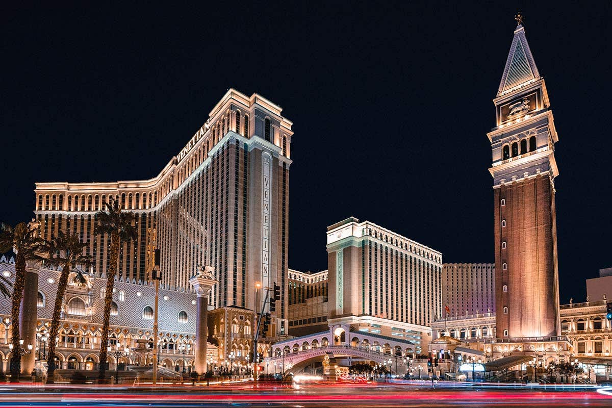 Night time view of The Venetian Resort exterior with the Campanile Tower, Venetian North Tower, and Venetian South Tower brightly lit.