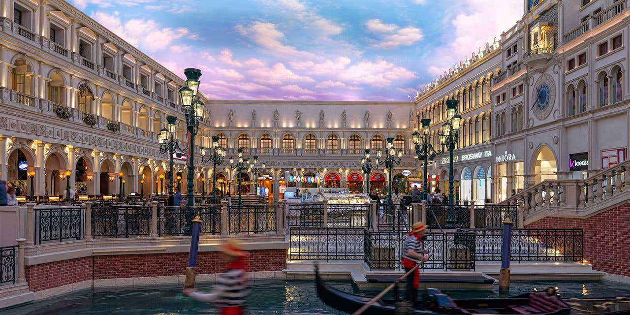 St. Mark’s Square in the Grand Canal Shoppes with gondoliers piloting gondolas in front.